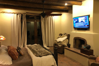 Diseño de dormitorio principal de estilo americano con paredes beige, suelo de ladrillo y todas las chimeneas
