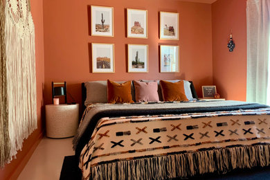 Ejemplo de dormitorio de estilo americano con parades naranjas, suelo de cemento y suelo gris