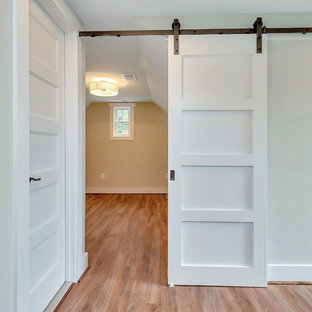 Imagen de dormitorio principal, contemporáneo, de tamaño medio, sin chimenea, con suelo de madera en tonos medios, paredes grises y suelo marrón