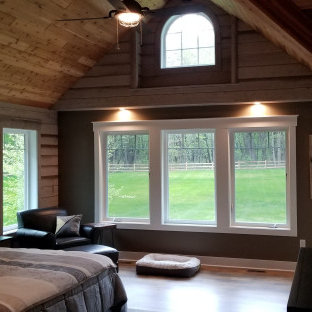 Foto de dormitorio principal, rural, con paredes grises, suelo vinílico y suelo marrón
