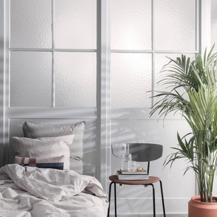 Photo of a scandinavian bedroom in Melbourne with white walls, grey floor and light hardwood floors.