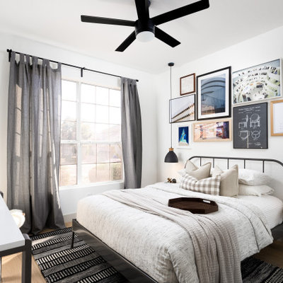 Example of a danish medium tone wood floor and brown floor bedroom design in Phoenix with white walls