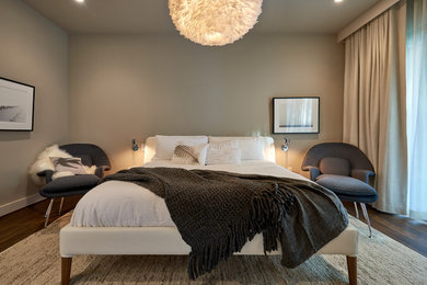 На фото: большая гостевая спальня (комната для гостей) в современном стиле с серыми стенами и темным паркетным полом