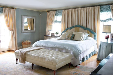 Foto de dormitorio principal tradicional renovado de tamaño medio sin chimenea con paredes azules y suelo de madera clara