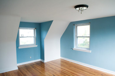 Mid-sized mid-century modern light wood floor bedroom photo in Other with blue walls