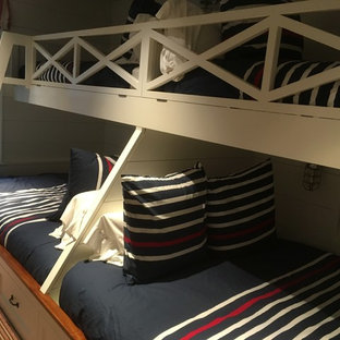 Imagen de habitación de invitados costera, de tamaño medio, sin chimenea, con moqueta, paredes blancas y suelo multicolor
