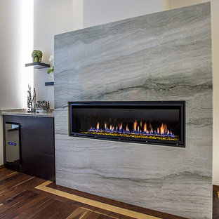 Imagen de dormitorio principal, moderno, grande, con chimenea lineal y marco de chimenea de piedra