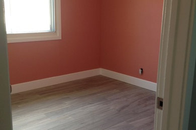 Cette photo montre une chambre d'amis exotique de taille moyenne avec parquet clair, aucune cheminée et un mur orange.