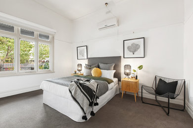 メルボルンにあるコンテンポラリースタイルのおしゃれな客用寝室 (白い壁、カーペット敷き、暖炉なし、グレーの床)