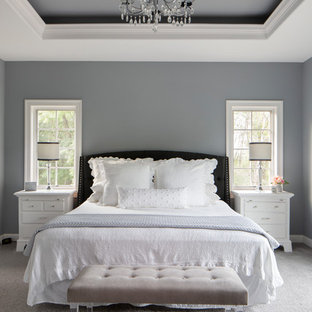 Imagen de dormitorio principal, de estilo americano, grande, con paredes grises, moqueta, suelo gris, chimenea de esquina y marco de chimenea de madera