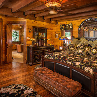 Diseño de dormitorio principal, rústico, grande, sin chimenea, con paredes marrones y suelo de madera oscura