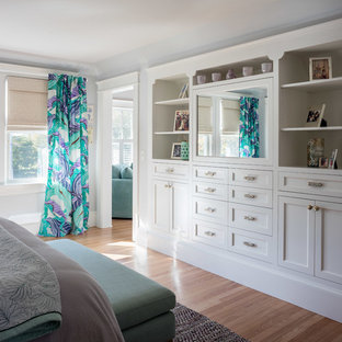 Imagen de dormitorio principal, clásico, grande, con paredes azules, suelo de madera en tonos medios y suelo naranja