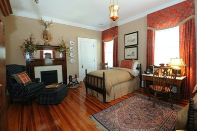 Ejemplo de habitación de invitados tradicional grande con paredes marrones, suelo de madera en tonos medios, todas las chimeneas, marco de chimenea de baldosas y/o azulejos y suelo marrón