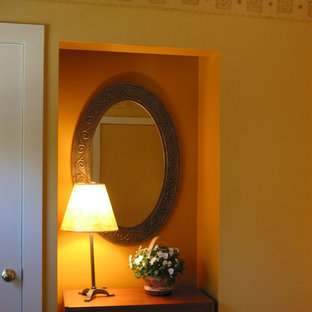 Modelo de habitación de invitados actual con paredes amarillas y suelo de madera clara