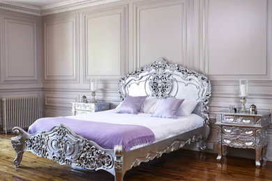 Diseño de dormitorio retro grande con paredes blancas, suelo de madera en tonos medios, suelo marrón y panelado