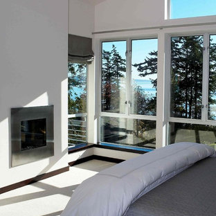 Modelo de dormitorio principal, moderno, de tamaño medio, con paredes blancas, moqueta, chimenea tradicional, marco de chimenea de metal y suelo blanco