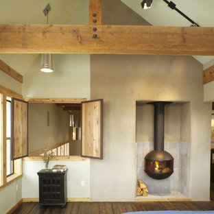 Uriges Schlafzimmer mit weißer Wandfarbe, dunklem Holzboden und Kaminofen in Austin