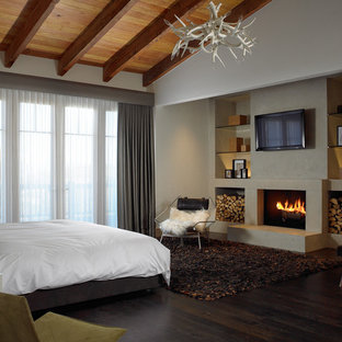 Diseño de habitación de invitados rural, de tamaño medio, con paredes blancas, suelo de madera oscura, chimenea tradicional, marco de chimenea de yeso y suelo marrón