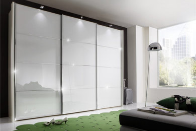 This is an example of a medium sized modern master bedroom in West Midlands with white walls.