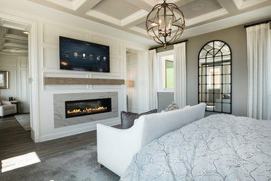 ロサンゼルスにある広いトラディショナルスタイルのおしゃれな主寝室 (グレーの壁、濃色無垢フローリング、両方向型暖炉、石材の暖炉まわり、グレーの床) のインテリア