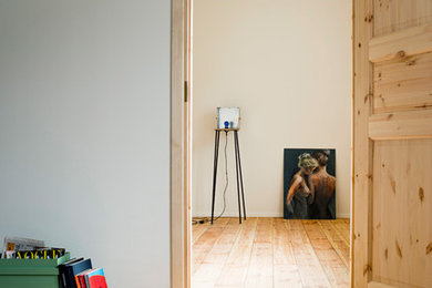 Foto di una piccola camera degli ospiti scandinava con pareti beige, pavimento in legno massello medio e nessun camino
