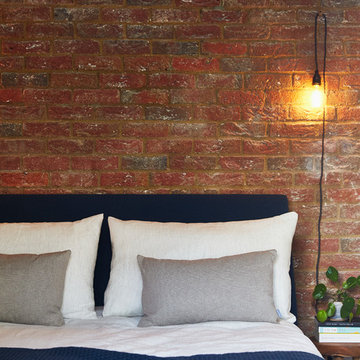 Soft Linen Bedding against the Exposed Brick Wall in this Guest Bedroom