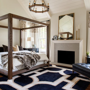 Landhausstil Schlafzimmer mit beiger Wandfarbe, dunklem Holzboden, Kamin, braunem Boden, freigelegten Dachbalken, Holzdielendecke und gewölbter Decke in Nashville