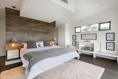Contemporary grey and cream bedroom in Sydney with white walls and dark hardwood flooring.