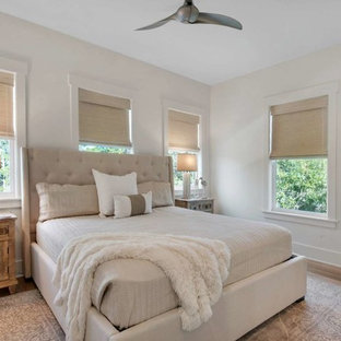 Example of a mid-sized beach style guest light wood floor and brown floor bedroom design in Miami with white walls and no fireplace
