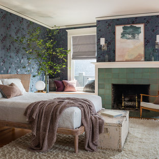 Modelo de dormitorio principal, de estilo americano, de tamaño medio, con paredes multicolor, suelo de madera en tonos medios, chimenea tradicional, marco de chimenea de baldosas y/o azulejos y suelo marrón