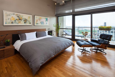 Diseño de dormitorio principal minimalista de tamaño medio sin chimenea con paredes grises y suelo de madera en tonos medios
