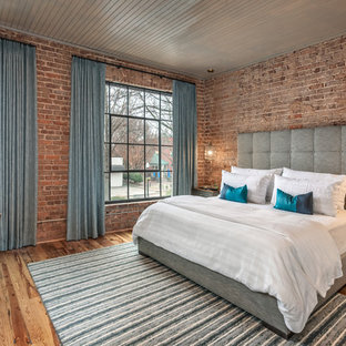 Imagen de habitación de invitados industrial, grande, con paredes rojas, suelo de madera en tonos medios y suelo marrón