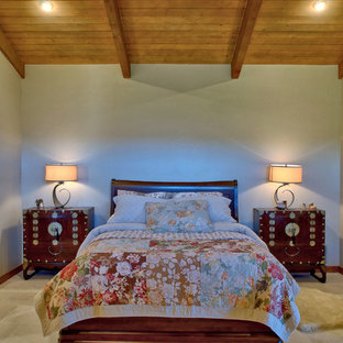 Diseño de dormitorio principal, campestre, con paredes beige, suelo de piedra caliza, chimenea de esquina, marco de chimenea de yeso y suelo blanco