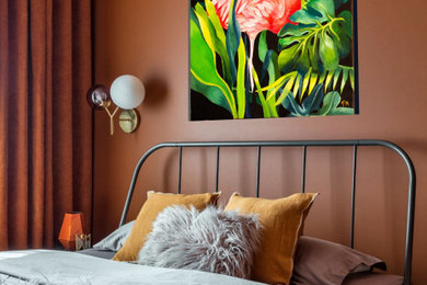 Идея дизайна: хозяйская спальня в современном стиле с оранжевыми стенами и полом из ламината