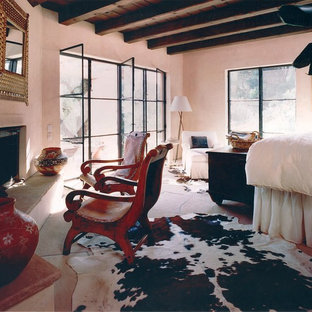 Großes Mediterranes Hauptschlafzimmer mit beiger Wandfarbe, Schieferboden, Eckkamin und Kaminumrandung aus Stein in Santa Barbara