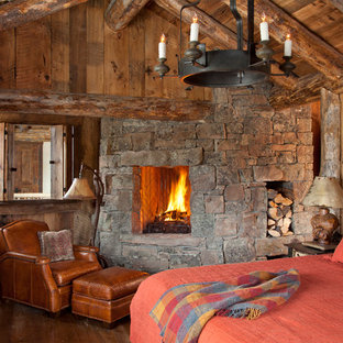 Idee per una camera da letto rustica con parquet scuro, cornice del camino in pietra e camino ad angolo