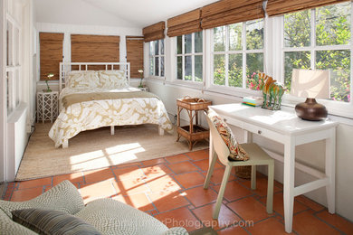 Immagine di una camera degli ospiti di medie dimensioni con pareti bianche, pavimento in terracotta e nessun camino