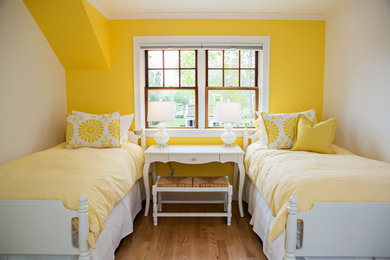Imagen de habitación de invitados clásica renovada de tamaño medio sin chimenea con paredes amarillas, suelo de madera en tonos medios y suelo marrón