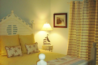 Mid-sized beach style guest medium tone wood floor bedroom photo in Jacksonville with blue walls