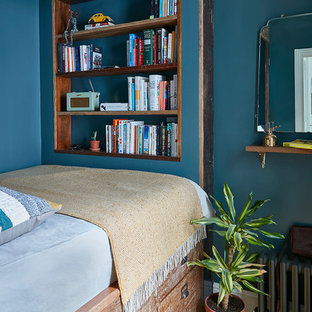 Design ideas for a small traditional guest bedroom in London with blue walls, medium hardwood flooring and brown floors.