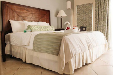 Medium sized beach style guest bedroom in Other with grey walls and travertine flooring.