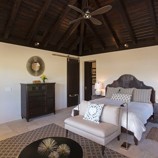 Imagen de habitación de invitados tropical con paredes blancas y suelo de travertino