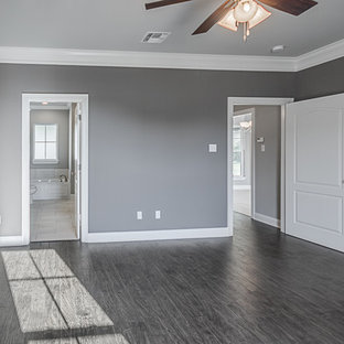 Modelo de dormitorio principal, tradicional, de tamaño medio, con paredes grises, suelo laminado y suelo gris