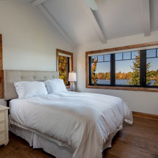 Rustikales Schlafzimmer mit weißer Wandfarbe, braunem Holzboden, braunem Boden, freigelegten Dachbalken und gewölbter Decke in Toronto