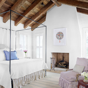 Photo of a country bedroom in Austin with white walls and a standard fireplace.