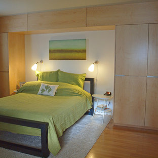 Diseño de dormitorio principal, actual, de tamaño medio, sin chimenea, con paredes beige, suelo de bambú y suelo marrón