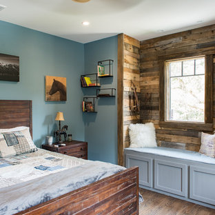 Modelo de dormitorio rústico, de tamaño medio, sin chimenea, con paredes azules, suelo de madera oscura y suelo marrón