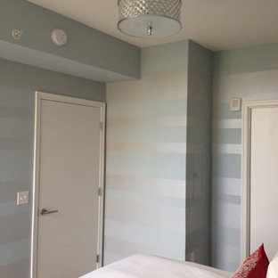 Modelo de habitación de invitados actual, grande, sin chimenea, con paredes azules y suelo de bambú