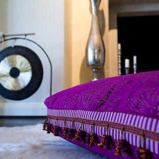 Ejemplo de dormitorio principal, bohemio, con suelo de madera oscura, chimenea tradicional y marco de chimenea de piedra