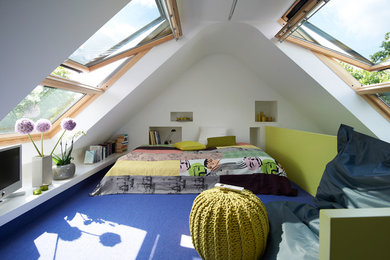 Ejemplo de dormitorio principal actual de tamaño medio sin chimenea con paredes blancas, moqueta y techo inclinado